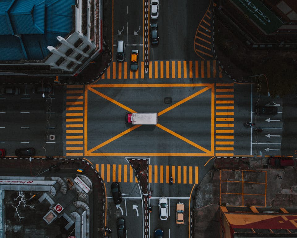 aerial cinematography view of city cars and people below